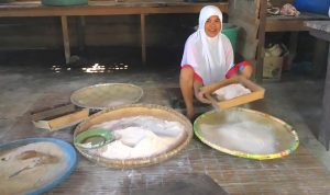 Seorang perempuan Maba Sangaji membakar sagu di forno menjadi sagu lempeng
